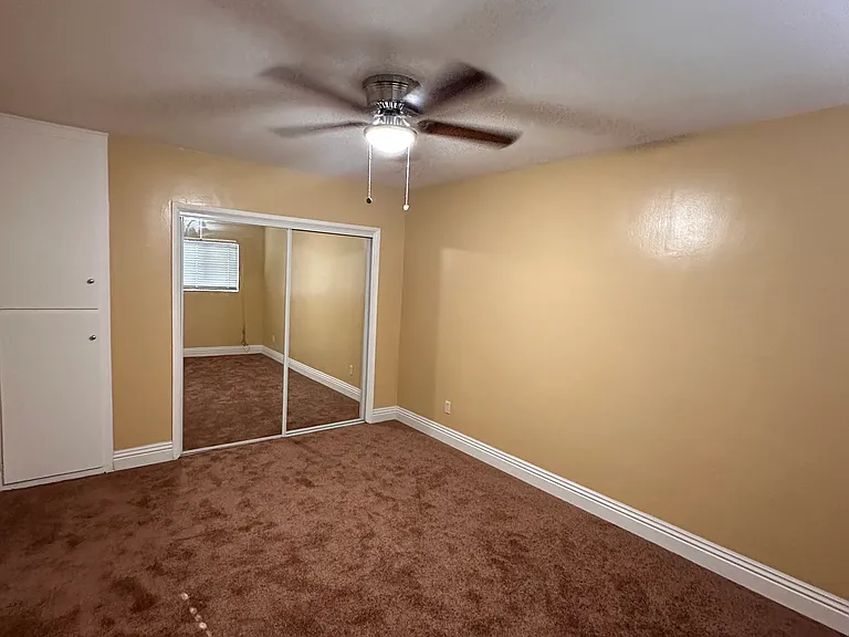 Bedroom #2 with mirrored closet doors and ceiling fan