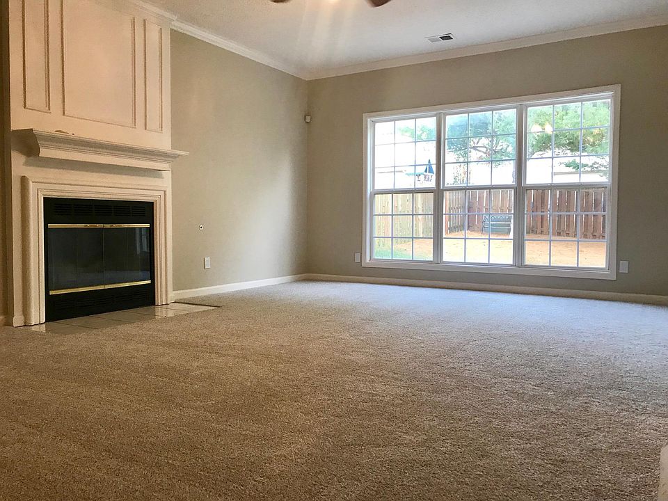 Large family room with gas fireplace, ceiling fan, and a view of the large fenced-in backyard! You'll love this house!