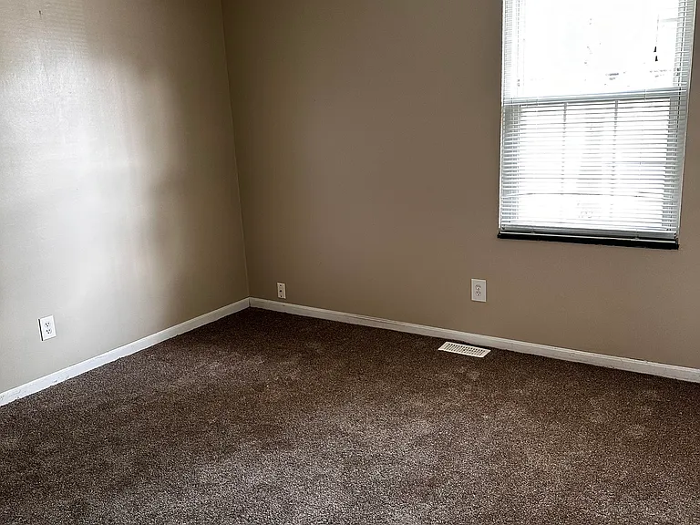 Bedroom 2 features a ceiling fan, a switched wall plug, a window with mini blinds and a curtain rod.
