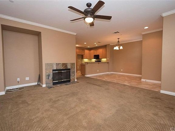 Large livingroom with entertainment niche and fireplace open to dining area and kitchen.