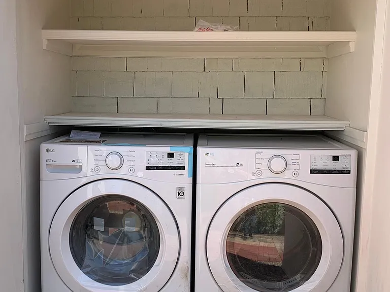 New washer and dryer for this unit only (not shared), with additional storage shelves above.