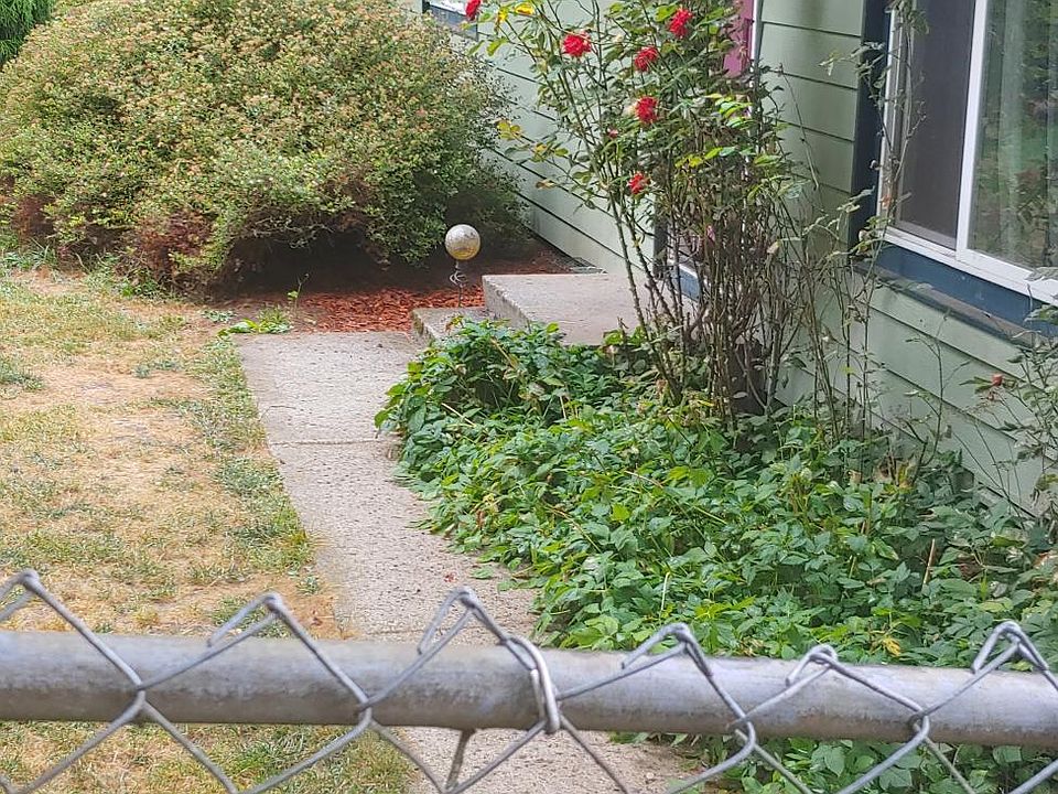 Frontyard facing road frontage. Unable to see yard from road. Cyclone fencing. Walkway to front door.
