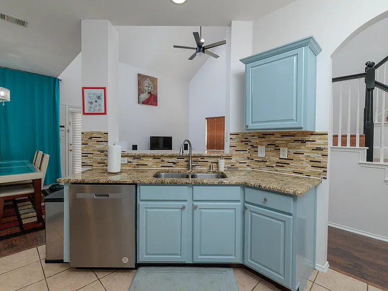 Open kitchen concept with all the major appliances with 2 bar top stools by the pass through. With the washer/dryer in laundry closet.