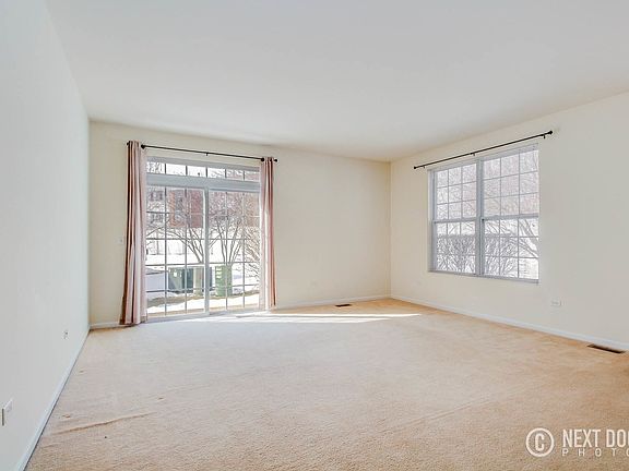 Large living room with access to the patio and overlooking the lush, green, open space.