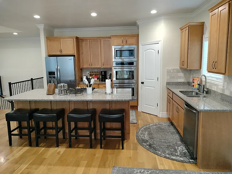 The fully furnished kitchen boasts a double oven, gas range, toaster, coffee station, spices, pots, pans, utensils, and sharp knives. It includes ample empty cupboard space for storage, providing everything you need for a seamless cooking experience.