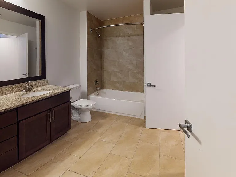 Apartment bathroom with tile flooring.