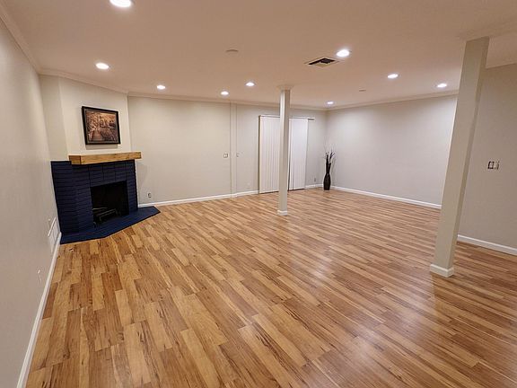 Very large and open living room / dining room space with newly remodeled fireplace, wood mantel, and recessed lighting