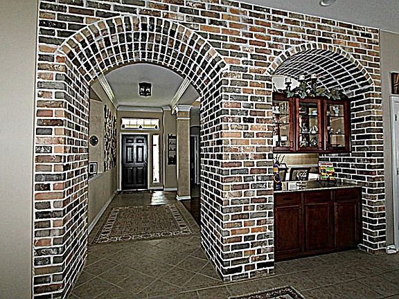 OPEN THE DOOR TO THE WELCOMING ENTRY WITH EXPOSED BRICK ARCHWAYS