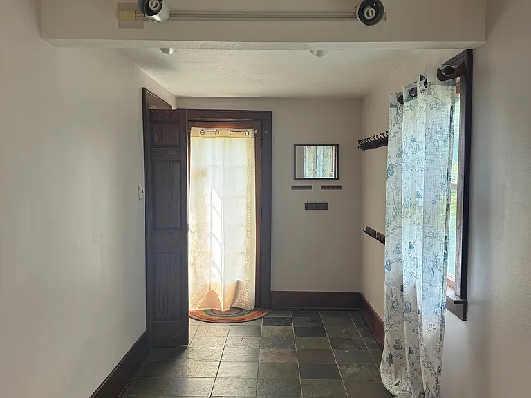 mudroom going to backyard and smaller half bath on left