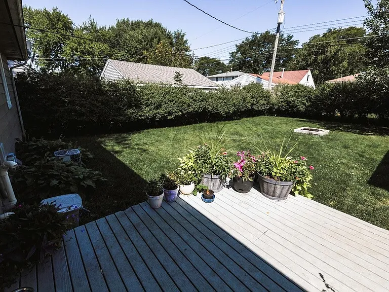 Backyard with privacy bushes lining fenced in area