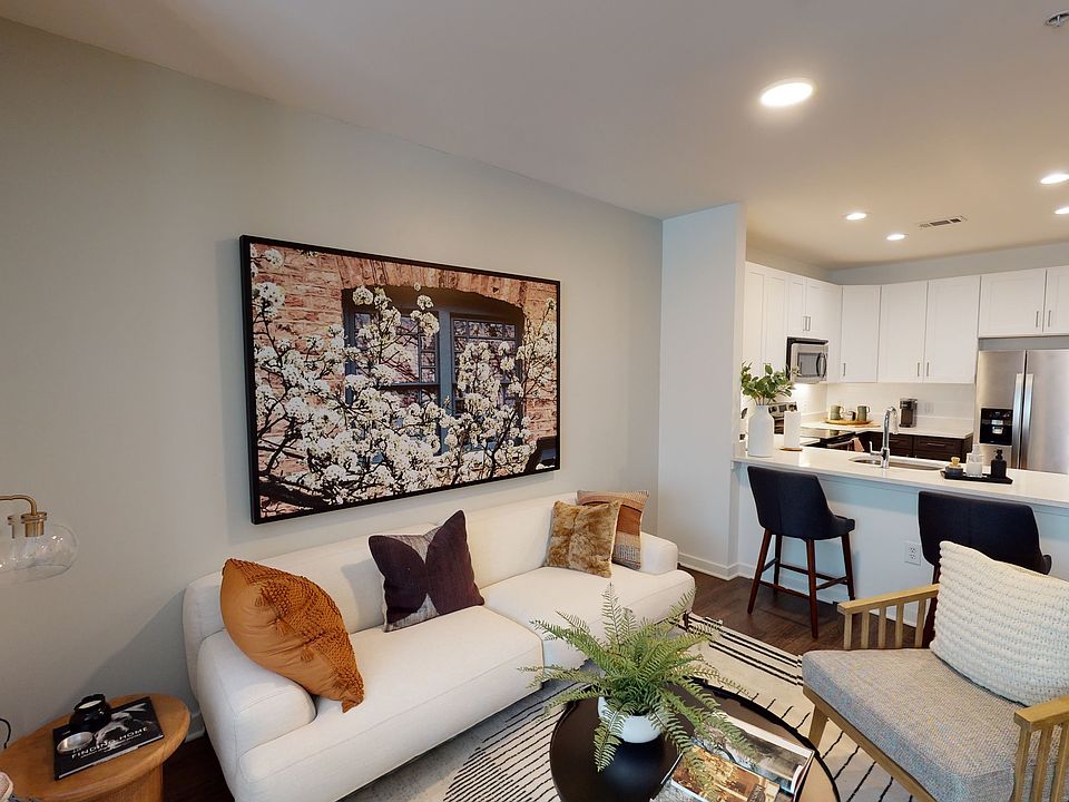 Open kitchen meticulously reimagined with two-tone cabinets, quartz counters, and stainless steel appliances