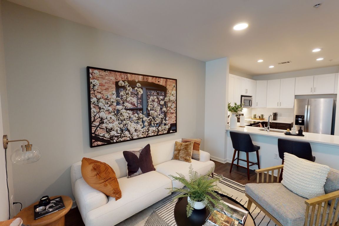 Open kitchen meticulously reimagined with two-tone cabinets, quartz counters, and stainless steel appliances