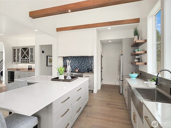 Chef's Kitchen: An open layout with top-tier stainless steel appliances, including a gas stove, expansive island