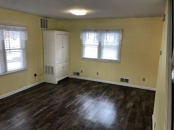 Living room with built in corner cabinet. First floor has recently updated vinyl wood flooring