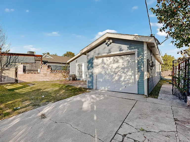 View of home's exterior with driveway, a garage, and an outbuilding