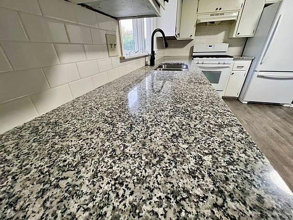 granite counter and tile backsplash