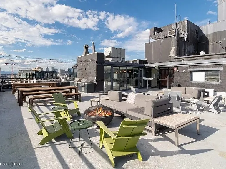 Rooftop patio with a fire pit and seating area at Archer Tower in Denver, CO