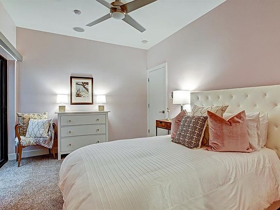 Spacious first floor bedroom featuring plush carpet, remote controlled ceiling fan, tall decorative baseboards, built-in speaker, ensuite bathroom and glass door leads to your private backyard space. Perfect as a guest bedroom