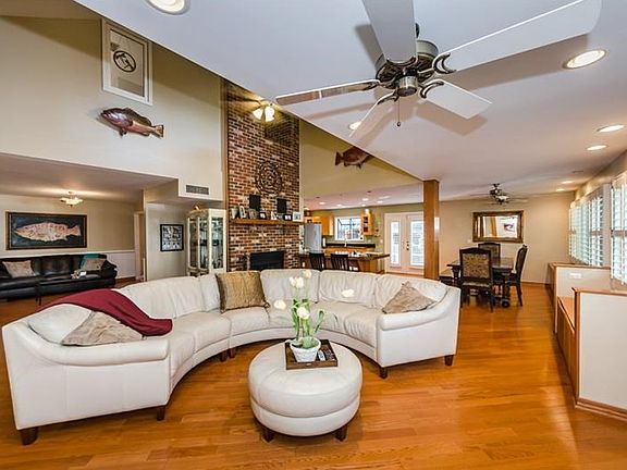 Gorgeous Great Room showing wood floors, wall of windows and 2 story fireplace