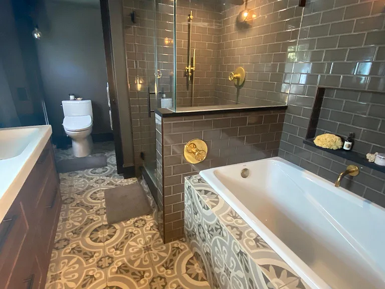 Brass fixtures, towel warmer, deep soaking tub, pocket door for private toilet.