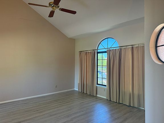 Formal living room with vaulted ceilings and fan