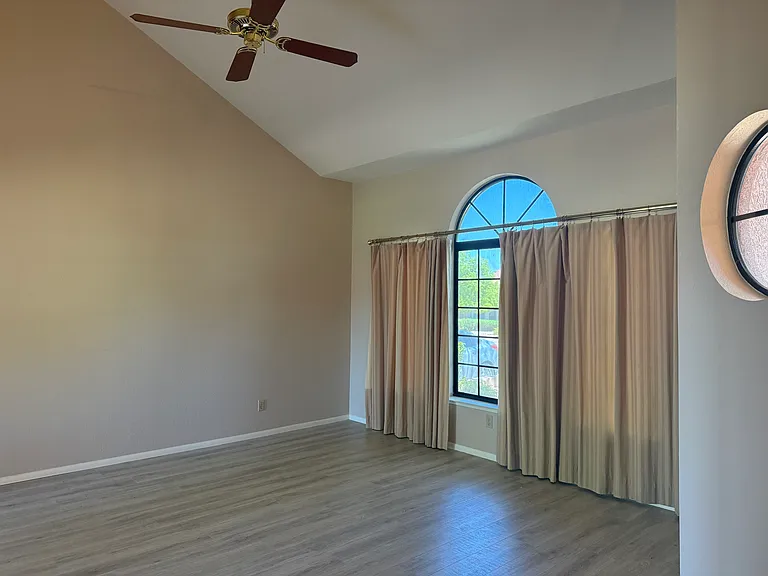 Formal living room with vaulted ceilings and fan