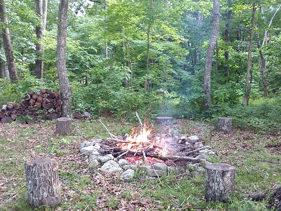 Fire pit in woods on lot.