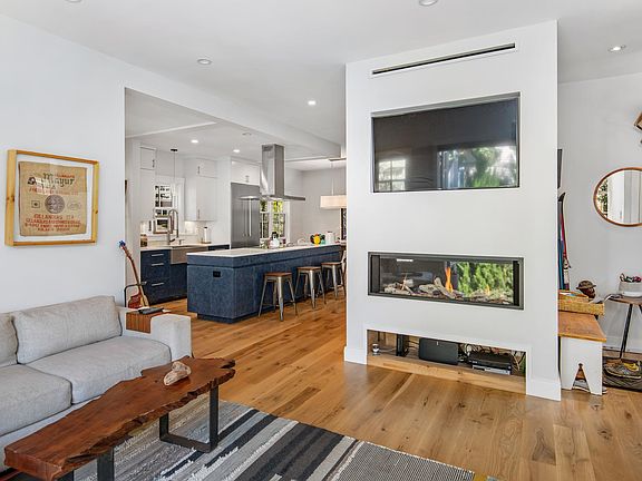 Living room with glass fireplace, open to chef's kitchen