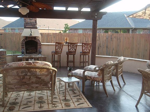 OUTDOOR PATIO WITH WOODEN PERGOLA /STONE & STUCCO F.P. W/ BAR/SITTING WALL.