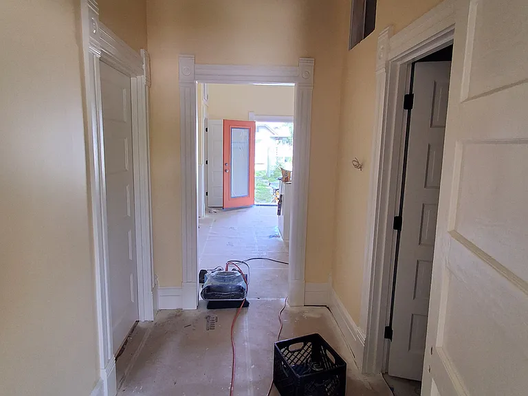 Central hallway looking from living room through kitchen to back yard. Main bath to right, master bed to left. July 22