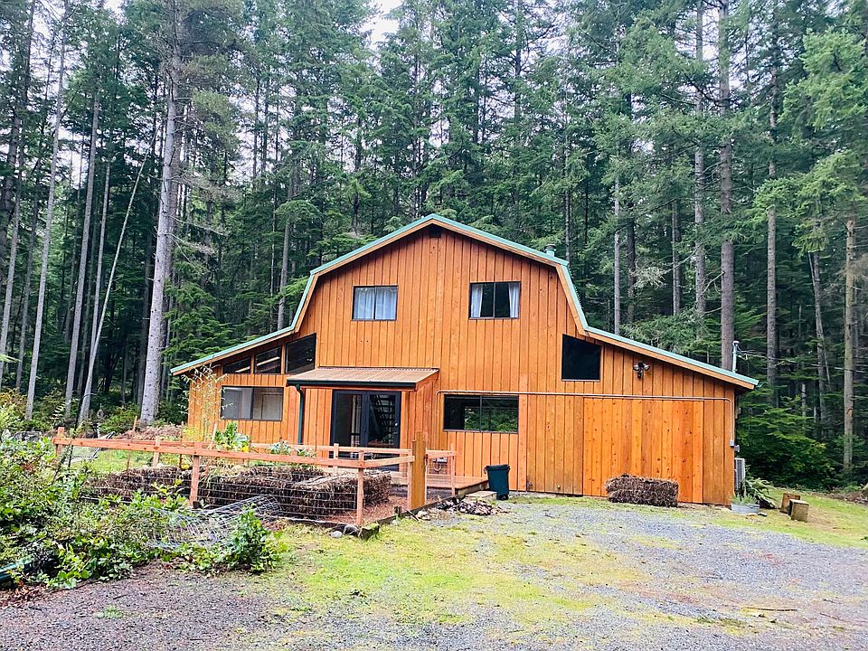 Front of the home. This charming home is on a very private 2-acre lot. Windows to the far left belong to BR#1. The window to the right of the front door is the kitchen. WIndows on the second level are the primary suite.