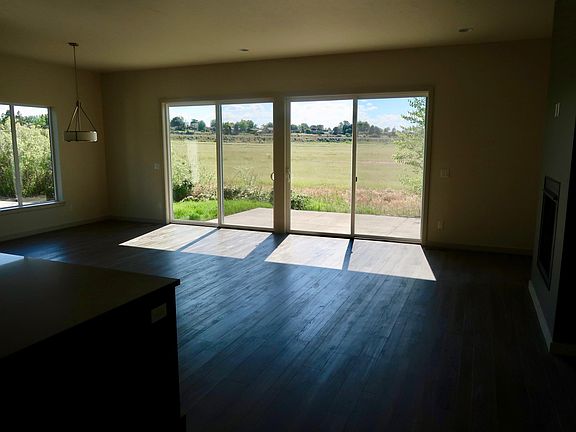 standing in the kitchen looking out the double sliding doors into open fields behind the house.