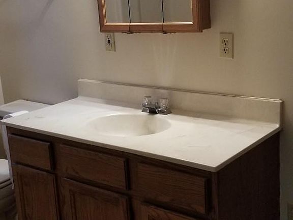 Bath has 2 storage closets and a tub with a shower.