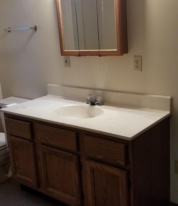 Bath has 2 storage closets and a tub with a shower.