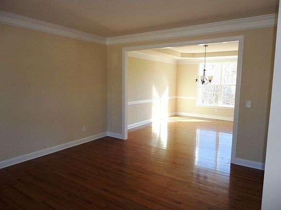 Step into formal living room with view of dining room beyond.
