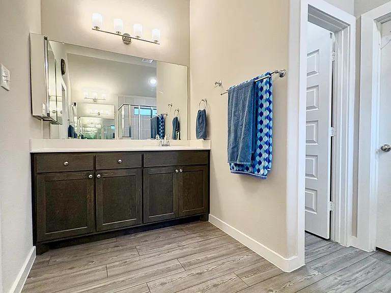 Large vanity with 2 drawers, 2 cabinets with shelves, double under sink cabinet, 3 shelf medicine cabinet, clothes hook & double towel bar.