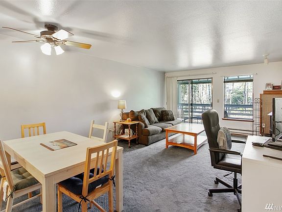 The main floor living room / dining room looks out to a large covered deck overlooking the fenced yard and green belt beyond. 