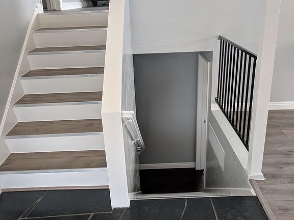 Entryway: upstairs to living room, balcony, bedroom #1 and bathroom. Downstairs to two bedrooms, bathroom, and storage.