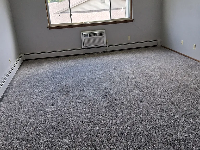 Large living room with sleeve air conditioner.