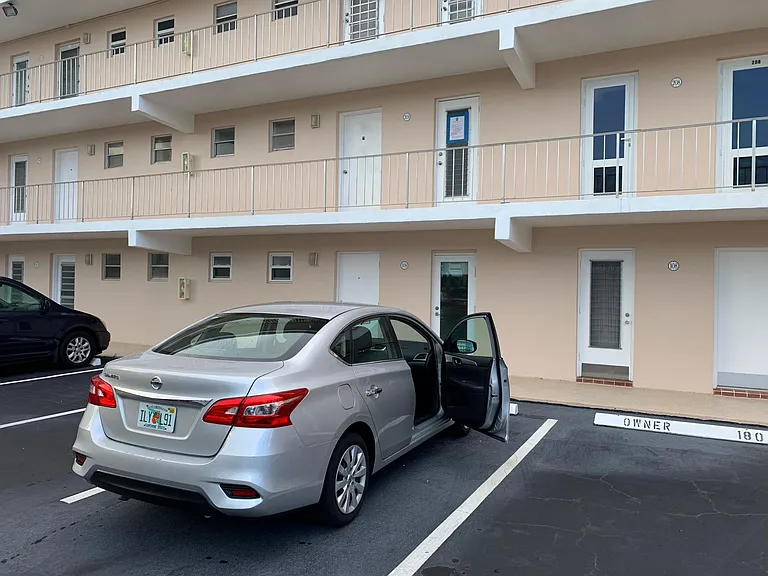 The door in front of the silver car