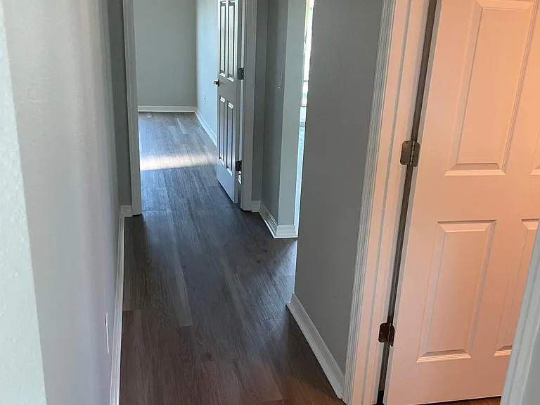 Hall with view to primary bedroom located at the rear of the house