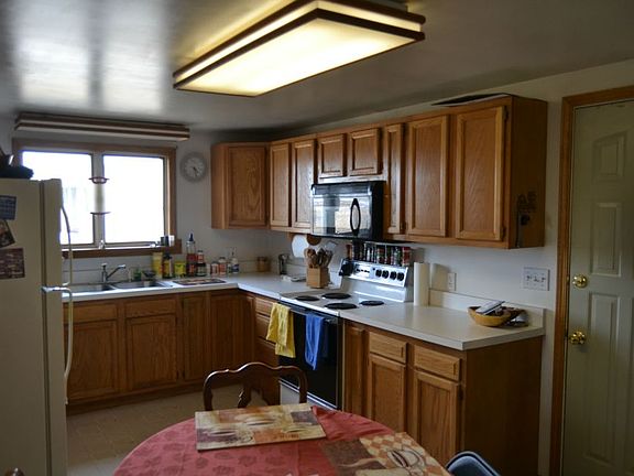 Just off the enclosed back porch is the Kitchen. It features newer Oak cabinets, a nice window over 