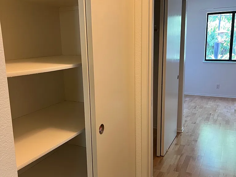 Hall closet and view of back downstairs bedroom
