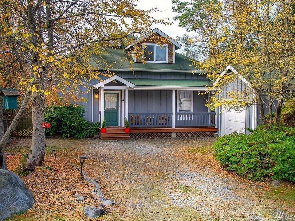 Home has covered wrap around porch which extends to the back yard.  To the right is one car garage w/bump out for addition shop space.