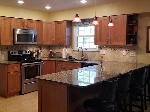 New kitchen with lots of granite counter space and seating, solid maple cabinets, custom tile backsplash, recessed lighting, sta
