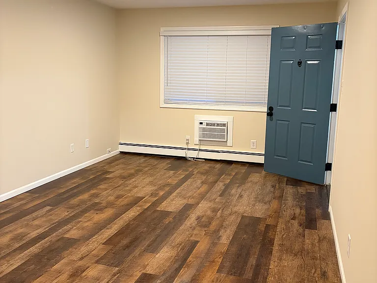 Living room with front door open.