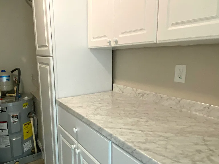 Opposite washer and dryer in laundry room, counter for folding clothes