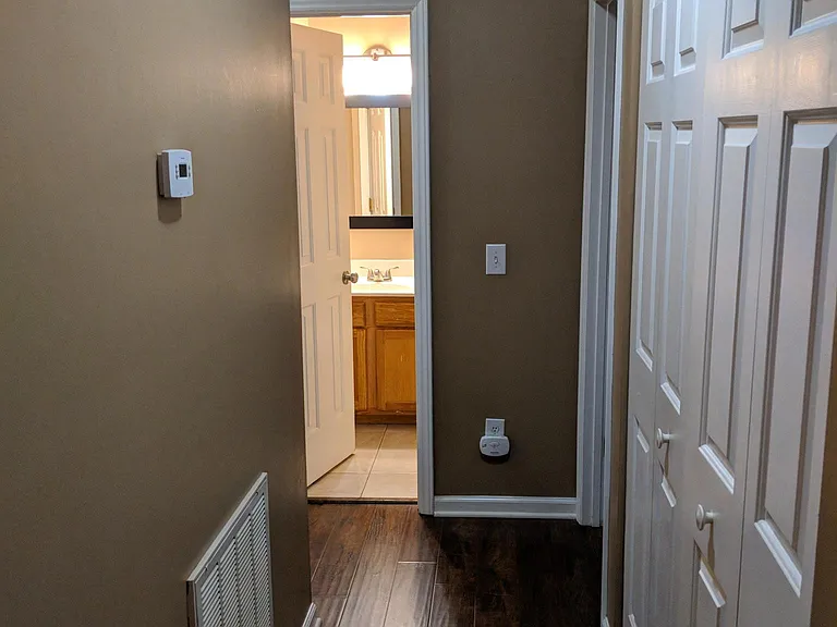 Hallway to bedrooms with laundry closet.