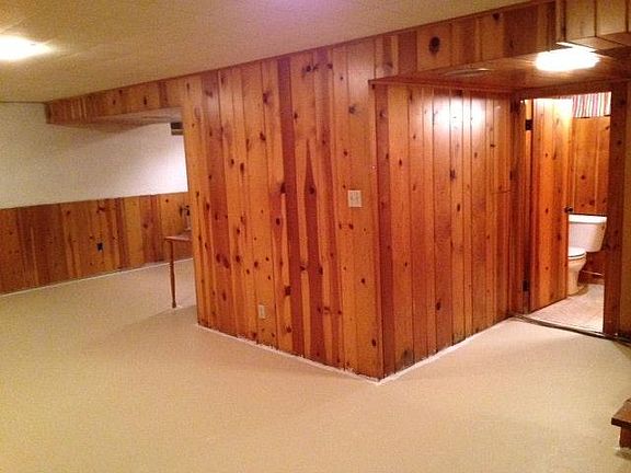 Basement with pine paneling and extra half bath provides lot