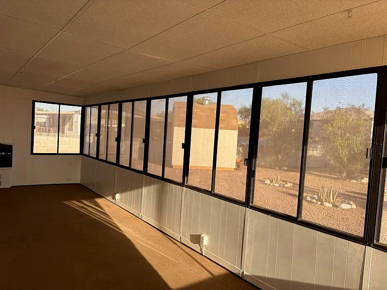 Sunroom has sunscreens on all the windows.